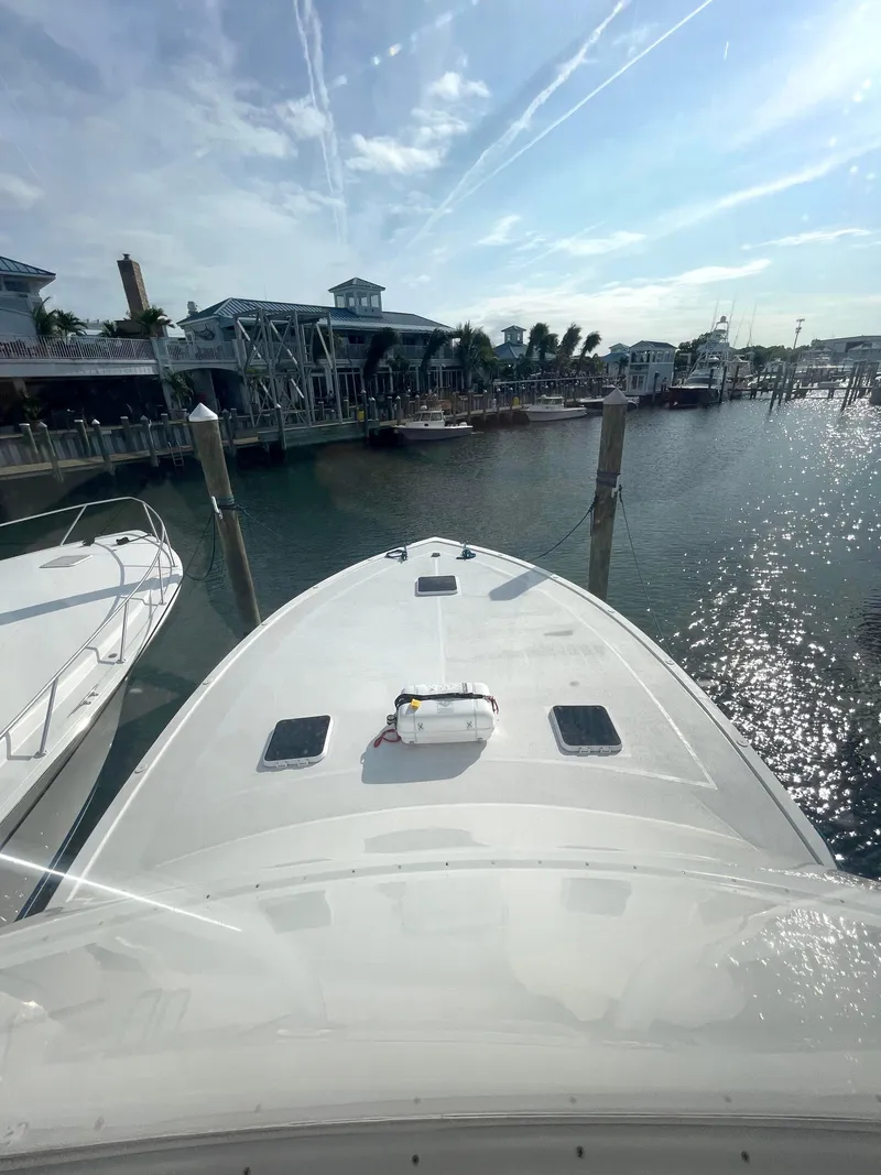 Slide: The Image of 1998 Post 42 Convertible yacht docked at marina under clear sky. - 38
