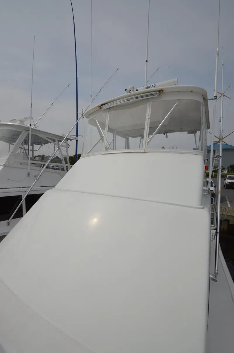 Slide: The Image of 1998 Post 42 Convertible yacht docked, featuring sleek white exterior and fishing rods. - 40