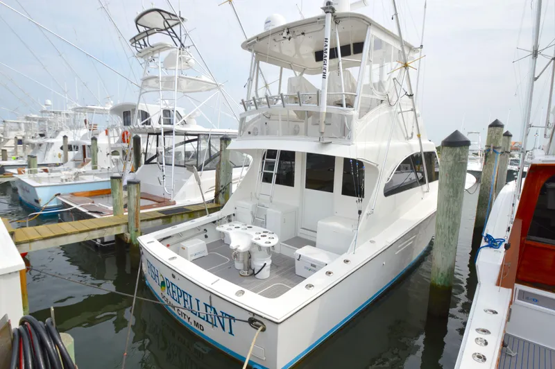 Slide: The Image of 1998 Post 42 Convertible yacht docked at marina, featuring spacious deck and fishing equipment. - 43