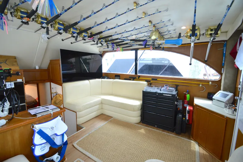 Slide: The Image of Interior of 1998 Post 42 Convertible yacht with fishing rods and cozy seating area. - 45