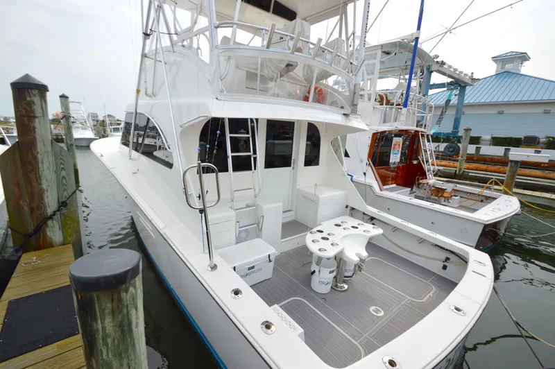 Slide: The Image of 1998 Post 42 Convertible yacht docked at marina, featuring spacious deck and fishing equipment. - 5