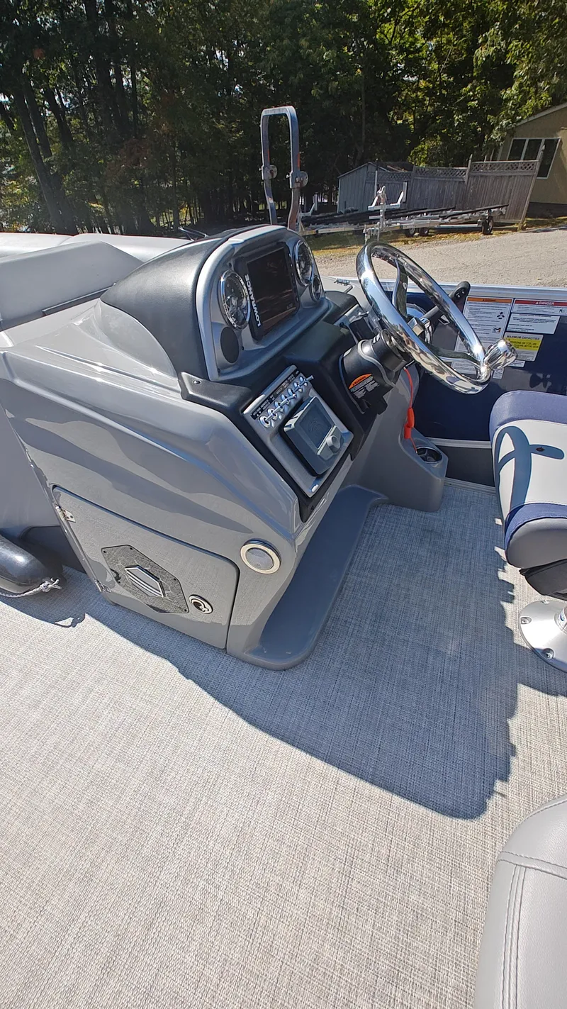 Slide: The Image of 2023 South Bay 523E 2.75 boat dashboard with steering wheel and controls. - 17