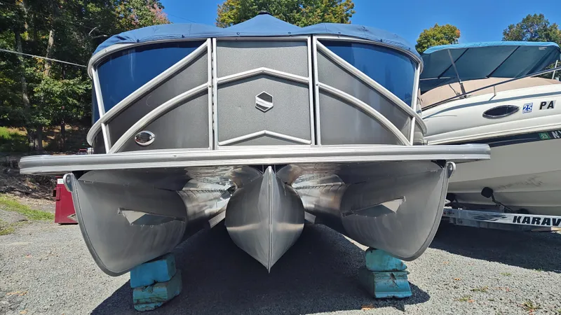 Slide: The Image of 2023 South Bay 523E 2.75 pontoon boat on display outdoors. - 2