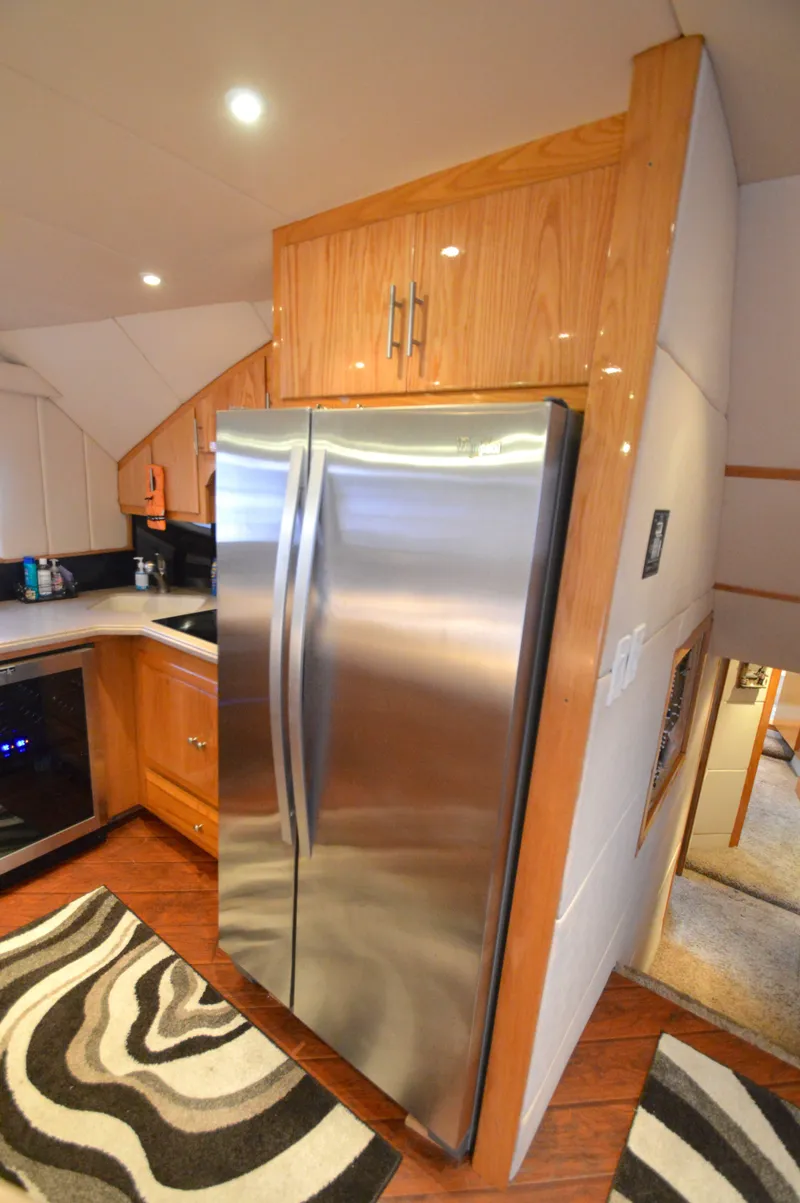Slide: The Image of Modern kitchen in 2004 Chesapeake 58 boat with stainless steel fridge and wood cabinetry. - 14