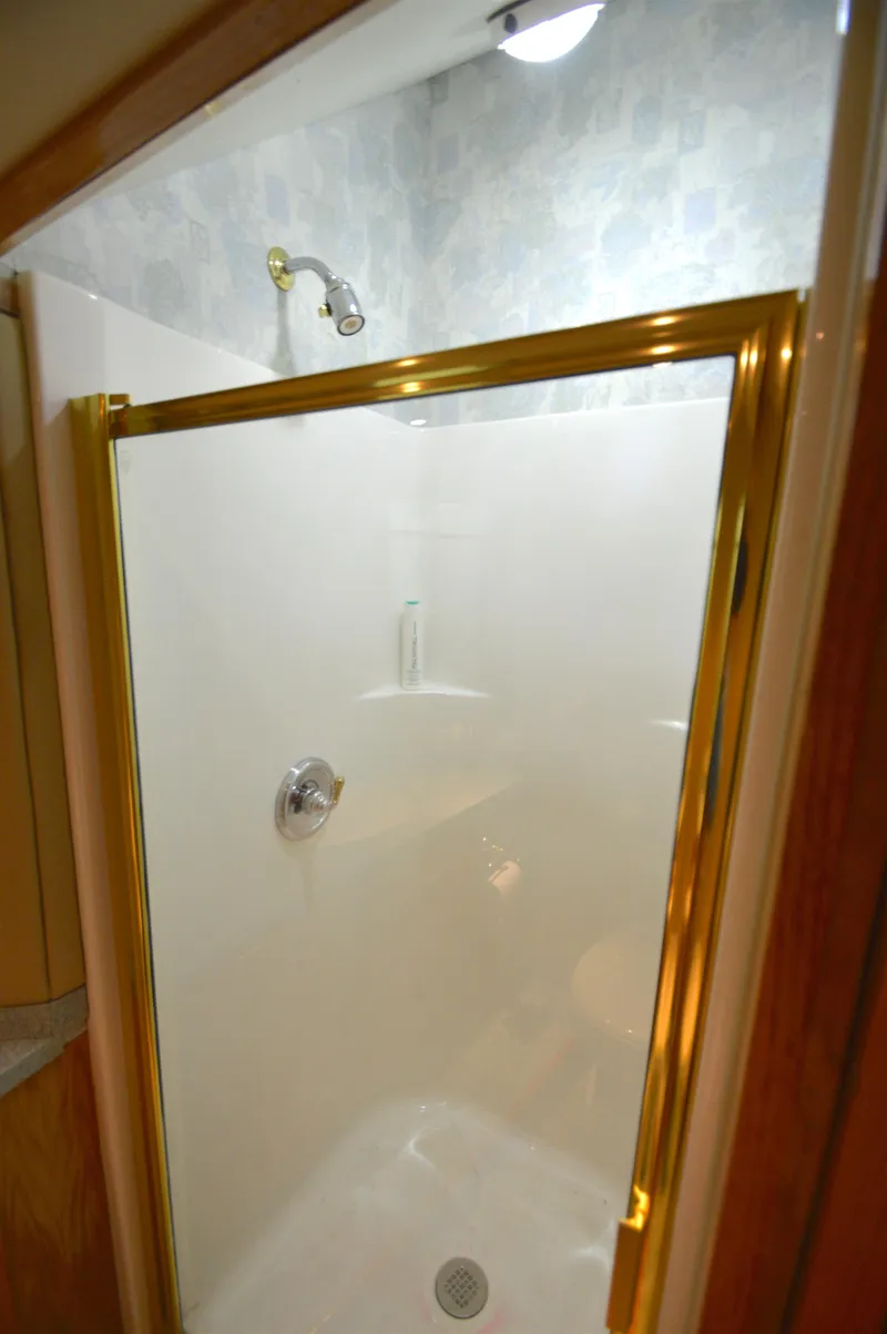 Slide: The Image of Shower area in 2004 Chesapeake 58 boat with gold trim and white walls. - 21