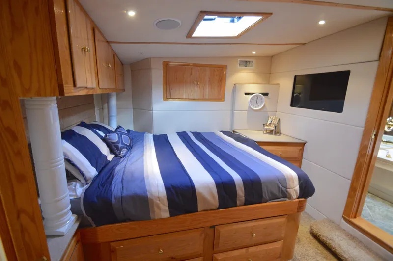 Slide: The Image of Luxurious cabin interior of 2004 Chesapeake 58 boat with striped bedding and wooden accents. - 22