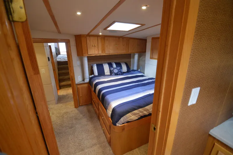 Slide: The Image of Luxurious 2004 Chesapeake 58 boat bedroom with striped bedding and wooden cabinetry. - 24