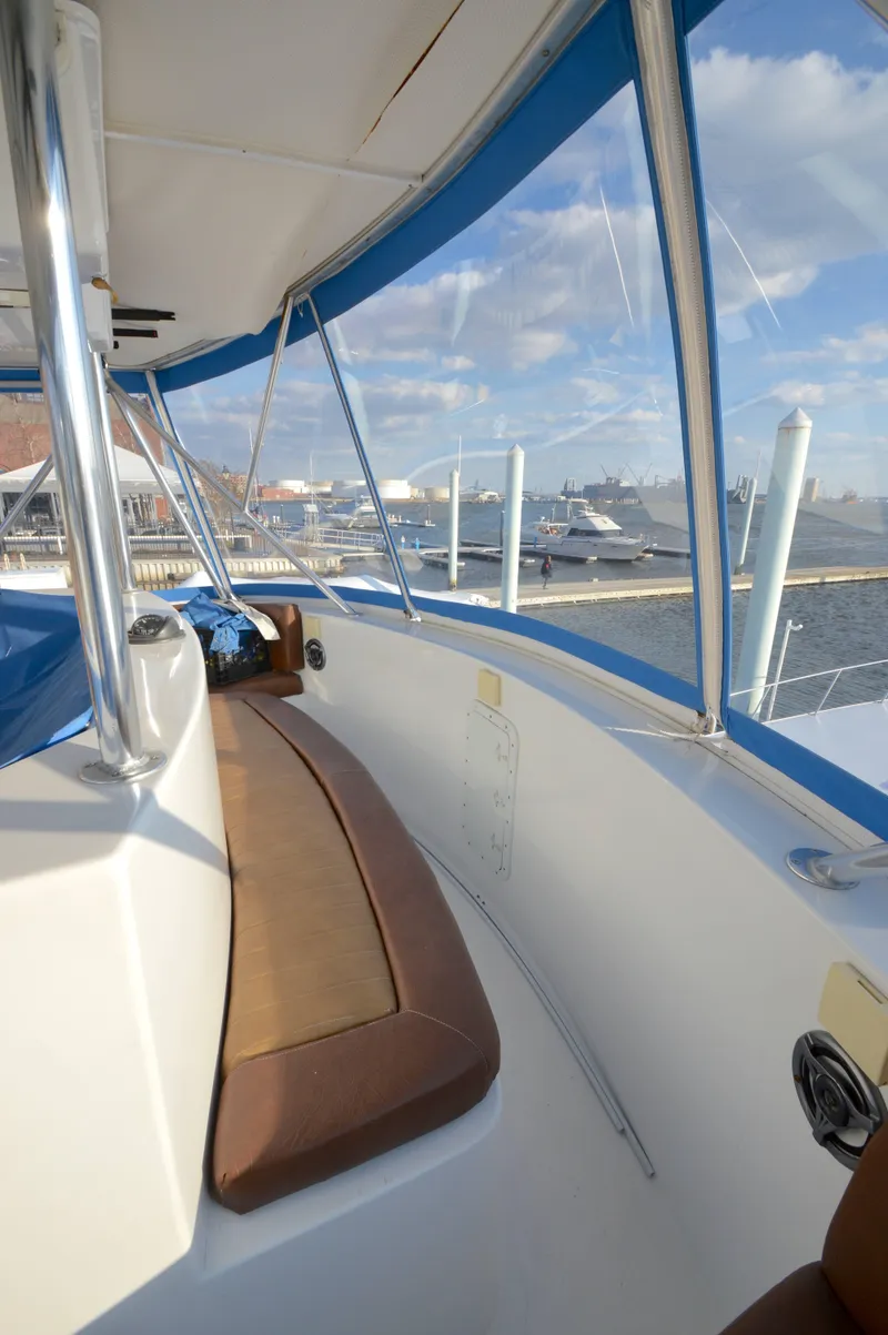 Slide: The Image of 2004 Chesapeake 58 boat interior with brown seating, overlooking marina and blue sky. - 31