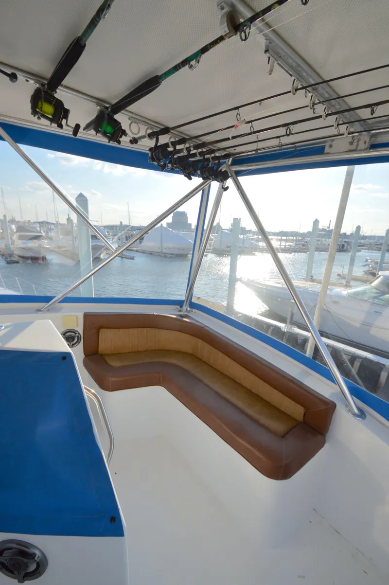 Slide: The Image of 2004 Chesapeake 58 boat interior with seating and fishing rods, docked at marina. - 34