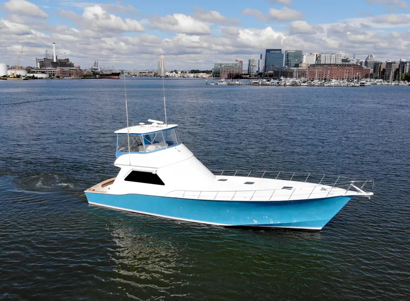 Slide: The Image of 2004 Chesapeake 58 boat cruising in a harbor with city skyline background. - 46