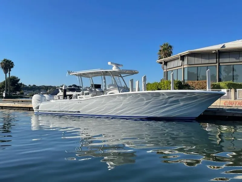 Slide: The Image of 2023 Mag Bay 33 CC boat docked on calm water, clear blue sky. - 0