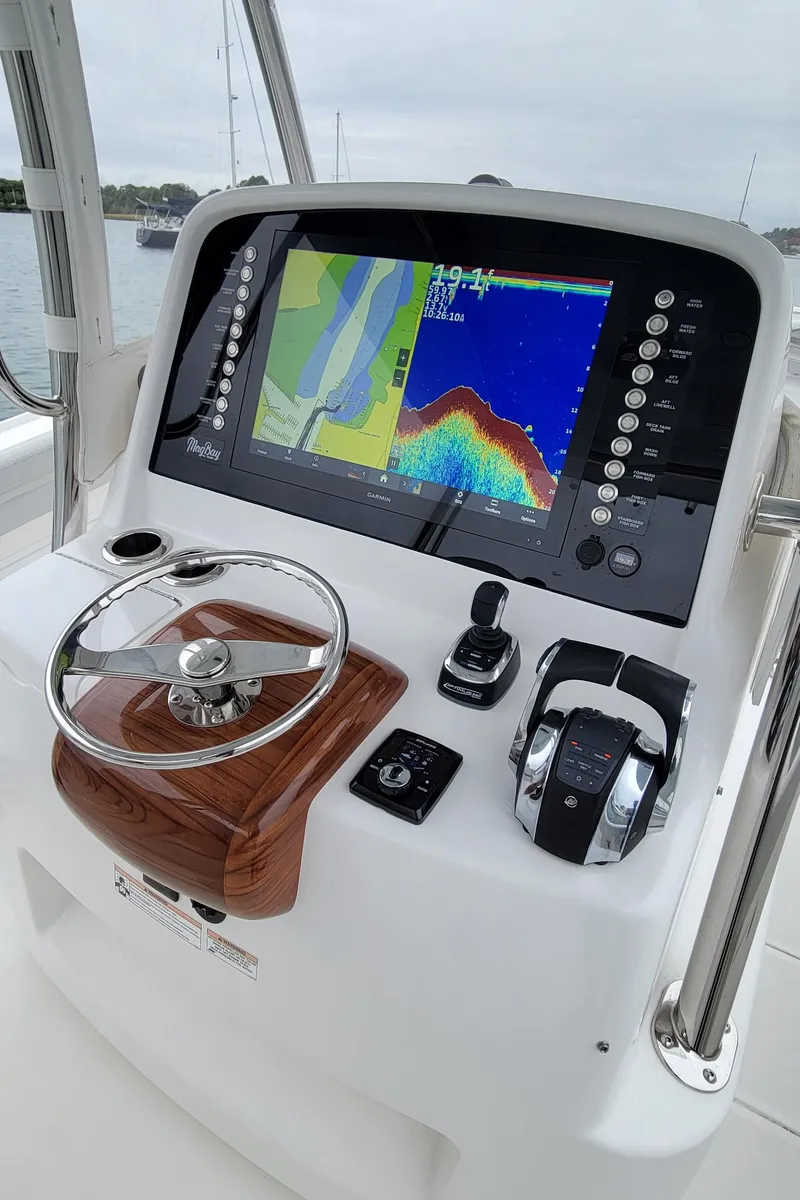 Slide: The Image of 2023 Mag Bay 33 CC boat dashboard with navigation display and controls. - 21