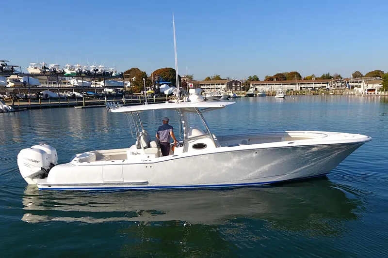 Slide: The Image of 2023 Mag Bay 33 CC boat on calm water, clear sky background. - 4