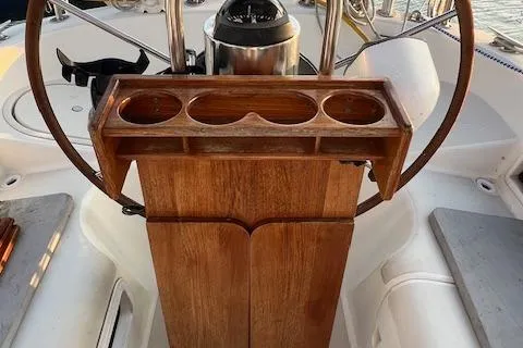 Slide: The Image of Wooden helm station on a 1986 Pearson 36 sailboat, featuring cup holders and steering wheel. - 10