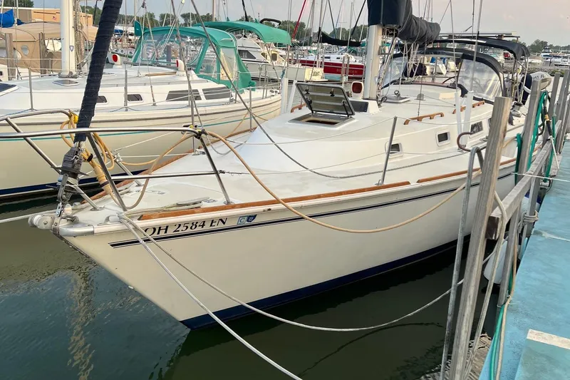Slide: The Image of 1986 Pearson 36 sailboat docked at marina, featuring sleek white hull and wooden trim. - 4