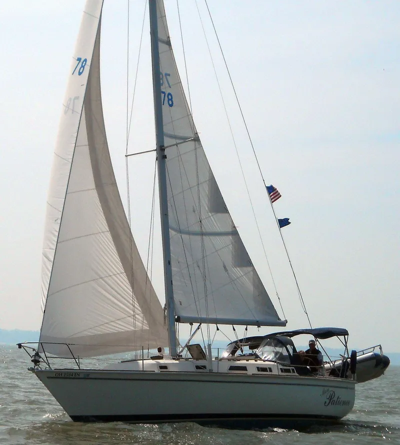 Slide: The Image of 1986 Pearson 36 sailboat on open water, sails raised, with American flag. - 5
