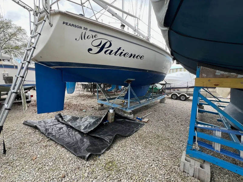 Slide: The Image of 1986 Pearson 36 sailboat named "More Patience" on a trailer in a boatyard. - 7