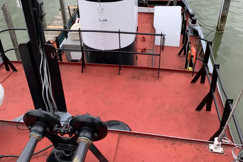 Slide: The Image of Red deck of a 1936 Tugboat Bow Steel, featuring railing and equipment. - 12