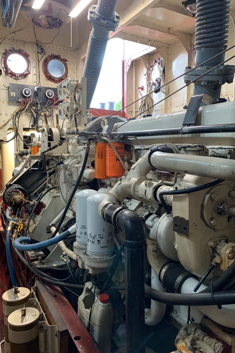 Slide: The Image of Engine room of a 1936 Tugboat Bow Steel, showcasing mechanical components and wiring. - 13