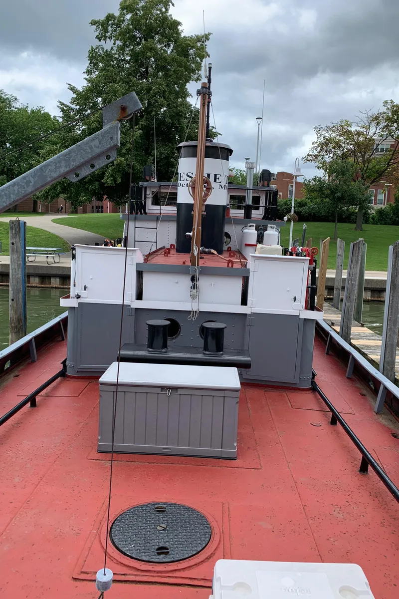Slide: The Image of 1936 Tugboat Bow Steel docked, showcasing its classic design and vibrant red deck. - 17