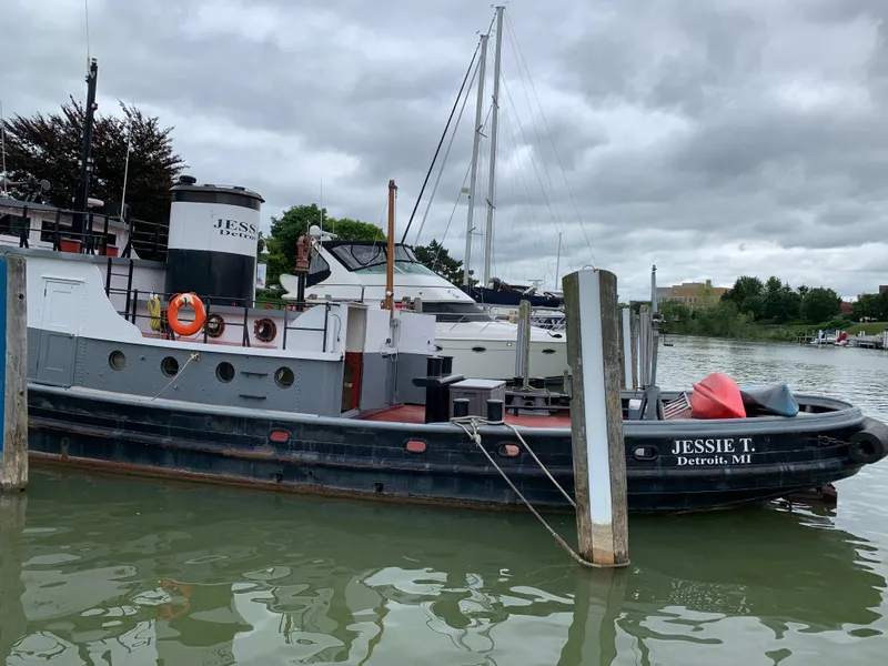 Slide: The Image of Vintage 1936 Bow Steel tugboat docked in a harbor, overcast sky. - 2