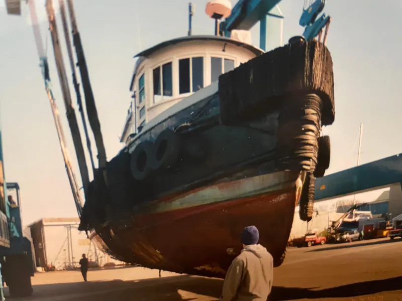 Slide: The Image of 1936 Tugboat Bow Steel in dry dock, viewed from below, with person observing. - 8