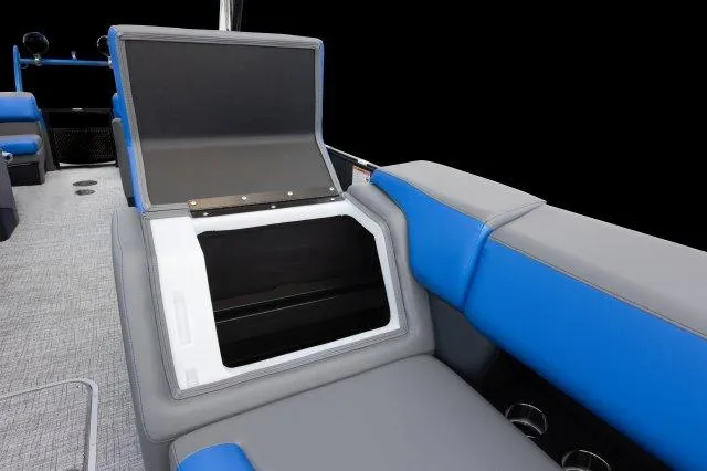 Slide: The Image of 2024 Berkshire 23RFX-STS3 boat interior with open storage compartment, blue and gray seating. - 13