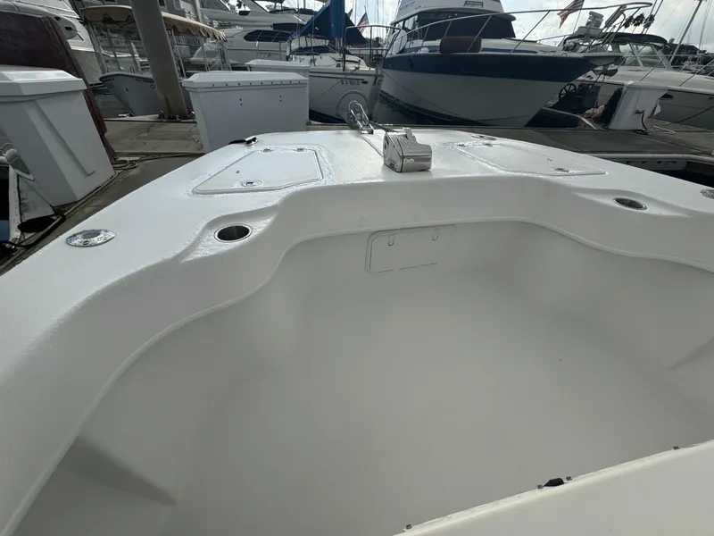 Slide: The Image of 2021 Twin Vee Catamaran boat interior at marina, showcasing spacious design and docked vessels. - 12