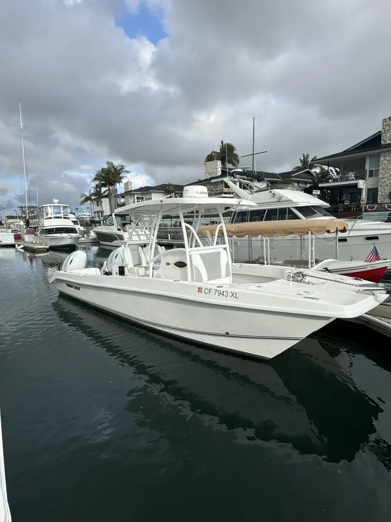 Slide: The Image of 2021 Twin Vee Catamaran docked in a marina under cloudy skies. - 16