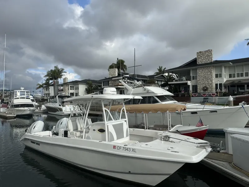 Slide: The Image of 2021 Twin Vee Catamaran docked at a marina with other boats under cloudy skies. - 17