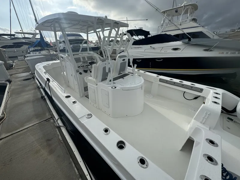 Slide: The Image of 2021 Twin Vee Catamaran docked, showcasing spacious deck and seating area. - 2