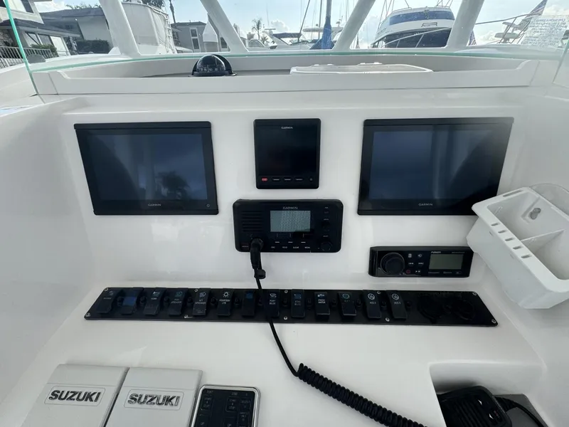 Slide: The Image of 2021 Twin Vee Catamaran dashboard with dual screens and Suzuki controls. - 6