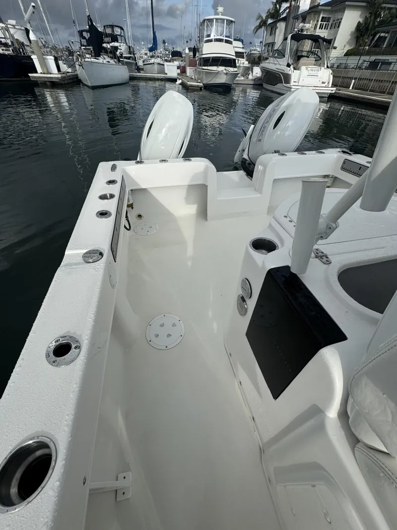 Slide: The Image of 2021 Twin Vee Catamaran docked in marina, showcasing spacious deck and seating area. - 9