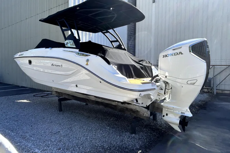 Slide: The Image of 2025 Hurricane SunDeck 2600 OB boat with Honda outboard motor, docked outdoors. - 11