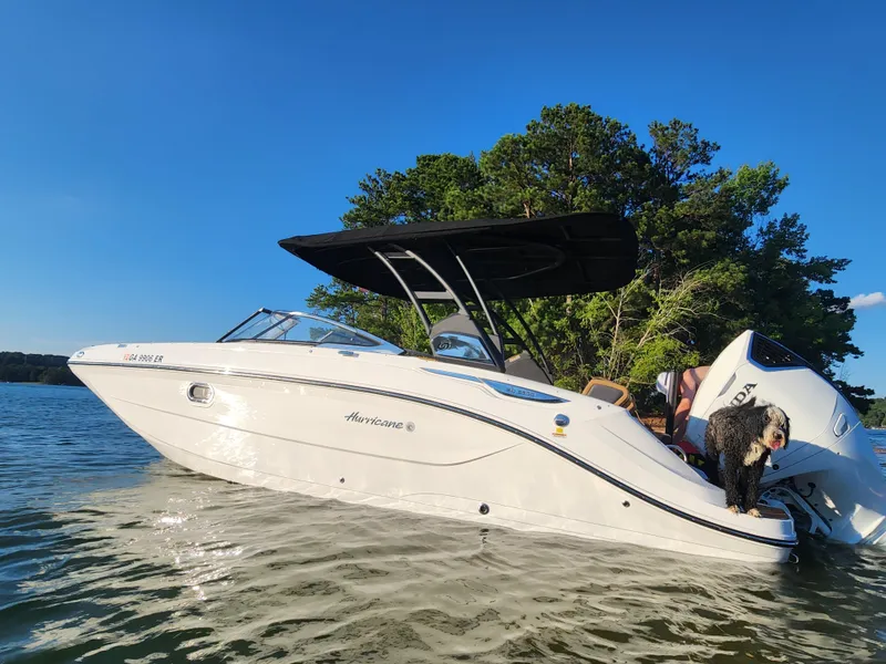 Slide: The Image of 2024 Hurricane SunDeck 2600 OB boat cruising on a scenic lake. - 6