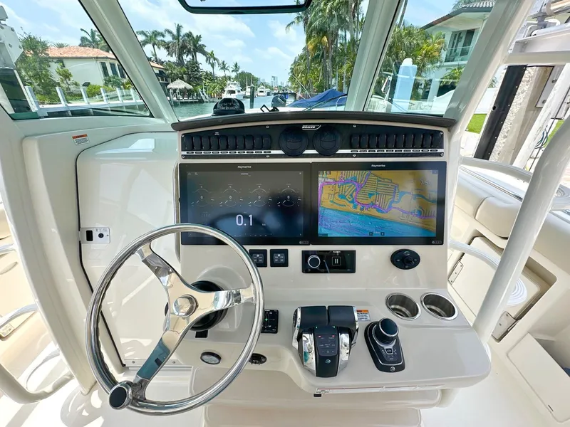 Slide: The Image of Boston Whaler 380 Outrage 2021 helm with dual displays and steering wheel. - 6