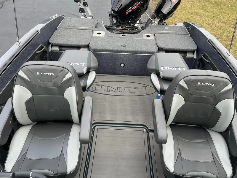 Slide: The Image of 2025 Lund 189 Tyee GL boat interior with four seats and a motor. - 17