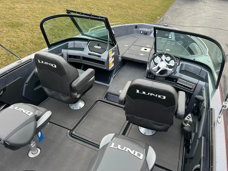 Slide: The Image of 2025 Lund 189 Tyee GL boat interior with black seats and modern dashboard. - 8