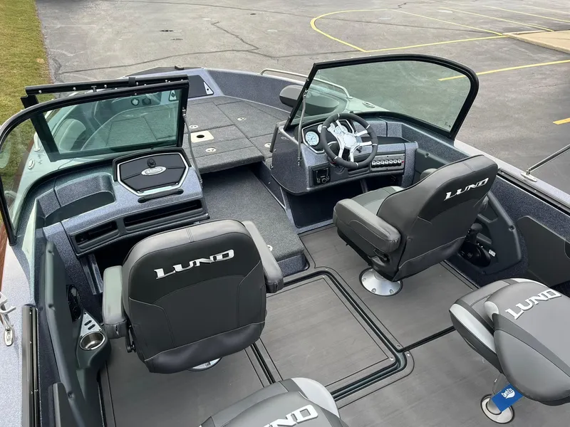 Slide: The Image of 2025 Lund 189 Tyee GL boat interior with black seats and modern dashboard. - 9