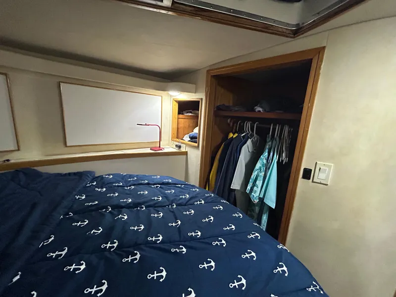 Slide: The Image of Cozy bedroom in 1988 Bertram 43 Convertible yacht with nautical-themed bedding. - 12