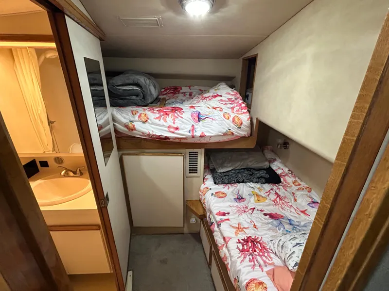 Slide: The Image of 1988 Bertram 43 Convertible cabin with bunk beds and adjacent bathroom. - 15