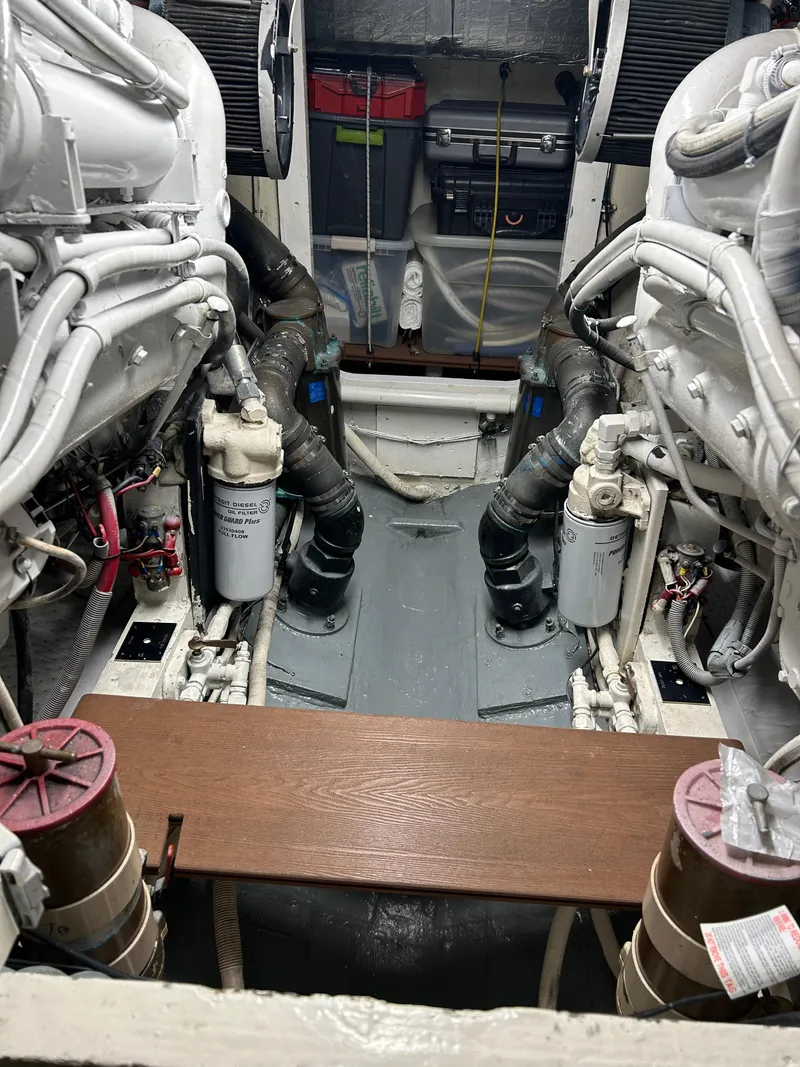 Slide: The Image of Engine room of a 1988 Bertram 43 Convertible boat, showcasing dual engines and mechanical components. - 6