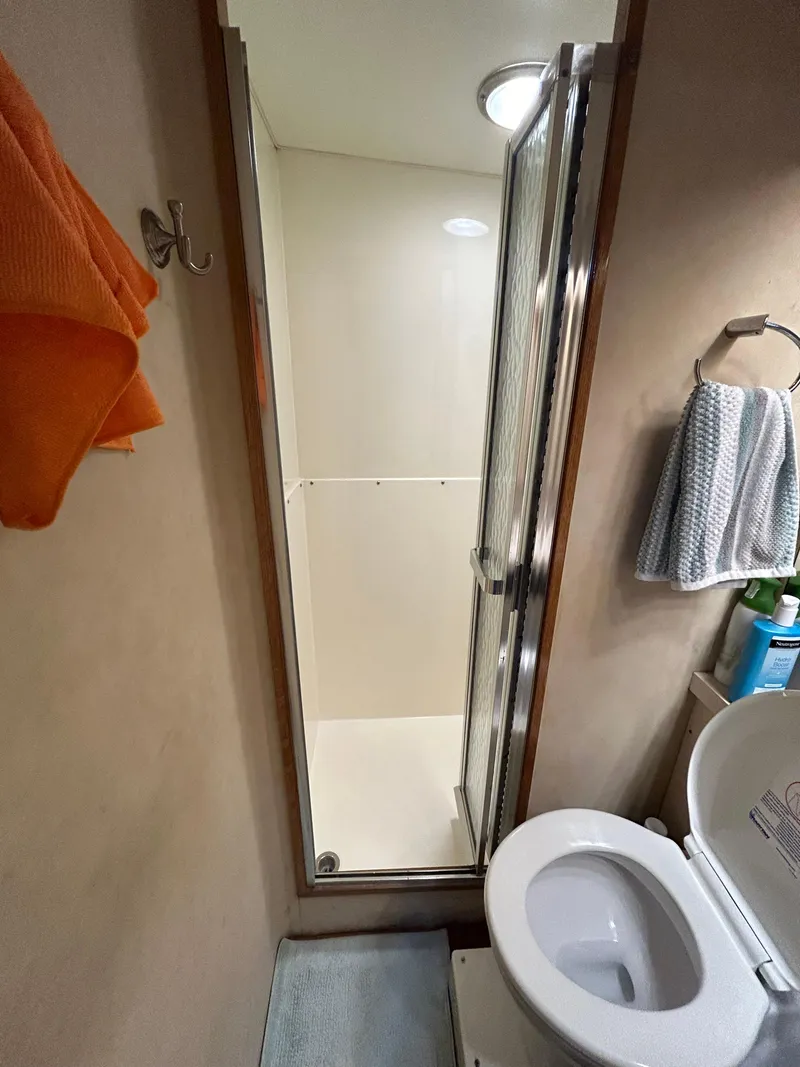 Slide: The Image of 1988 Bertram 43 Convertible bathroom with shower, toilet, and towels. - 9