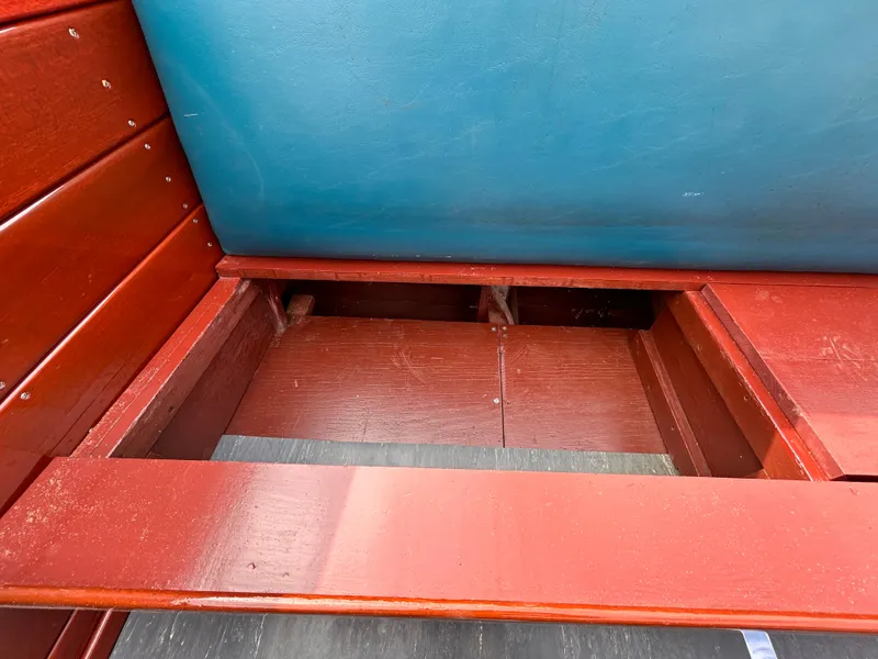 Slide: The Image of Interior view of a 1953 Chris-Craft 22 Sportsman boat, showcasing wooden seating and storage area. - 13