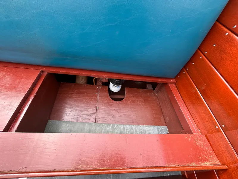 Slide: The Image of Interior view of a 1953 Chris-Craft 22 Sportsman boat, showcasing wooden seating and storage. - 15