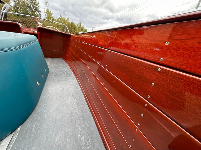 Slide: The Image of 1953 Chris-Craft 22 Sportsman boat interior with polished wooden panels and blue seating. - 18