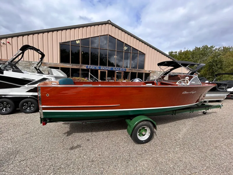 Slide: The Image of 1953 Chris-Craft 22 Sportsman boat displayed outside a sales building. - 2