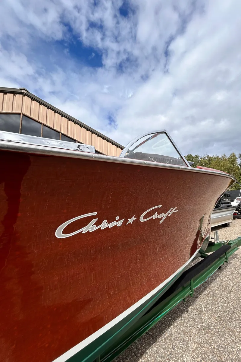 Slide: The Image of 1953 Chris-Craft 22 Sportsman boat with wooden finish under a cloudy sky. - 7
