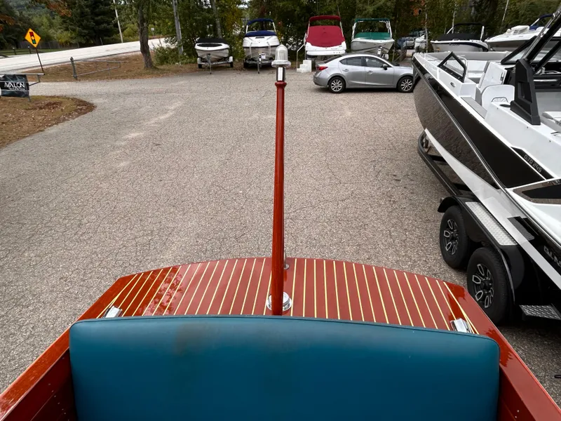 Slide: The Image of 1953 Chris-Craft 22 Sportsman boat in parking lot, surrounded by modern vehicles. - 9