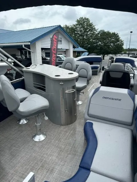 Slide: The Image of 2023 Berkshire 24ULE-STS3 pontoon boat with seating and bar area, displayed outdoors. - 7